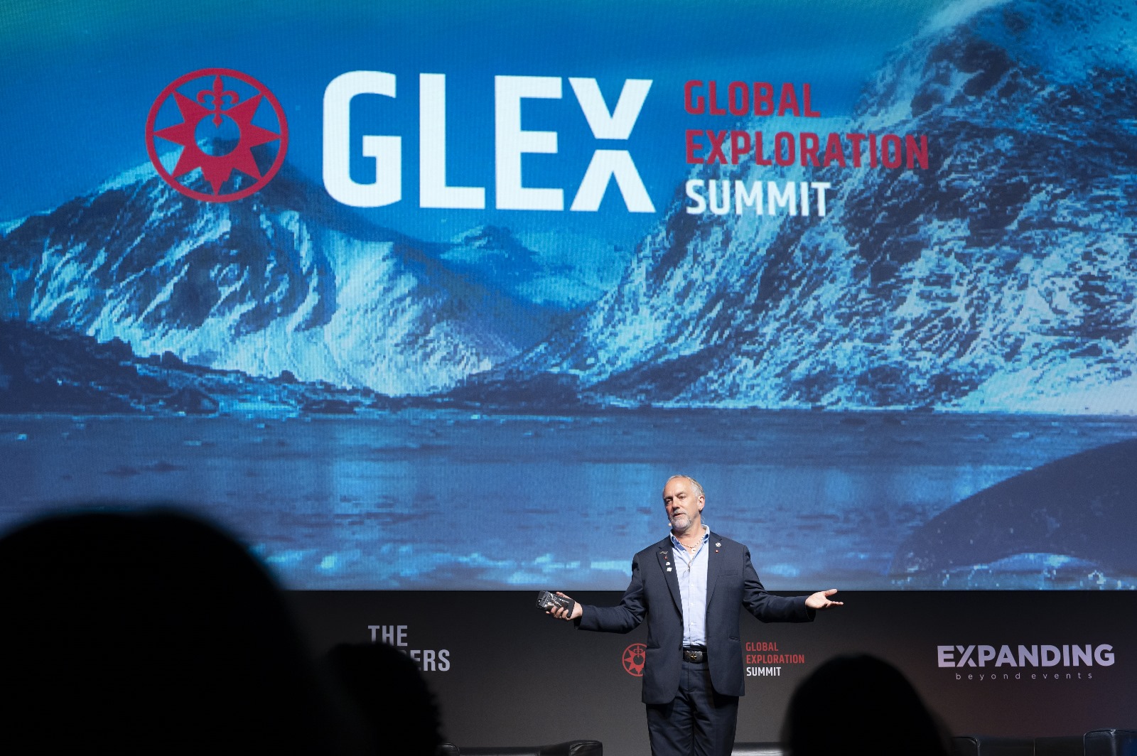 Orador em palco da GLEX Summit com imagem da Antártida projectada ao fundo