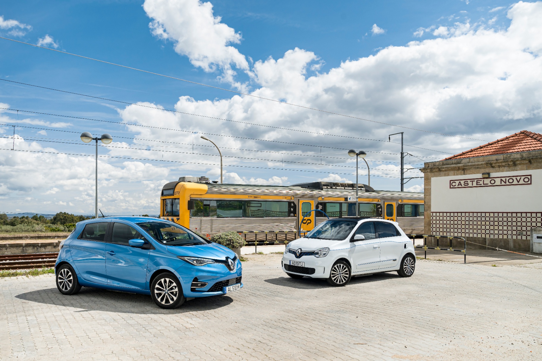 Renault Zoe azul e Twingo Electric branco junto à estação ferroviária de Castelo Novo