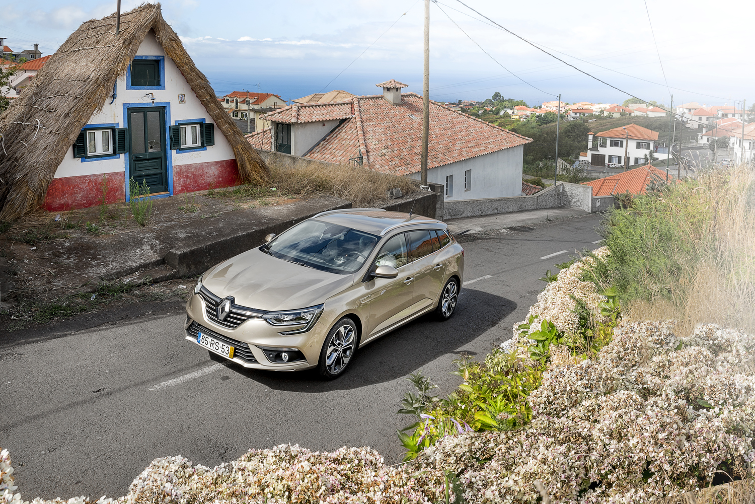 Mégane Sport Tourer junto a casa tradicional de colmo em Santana