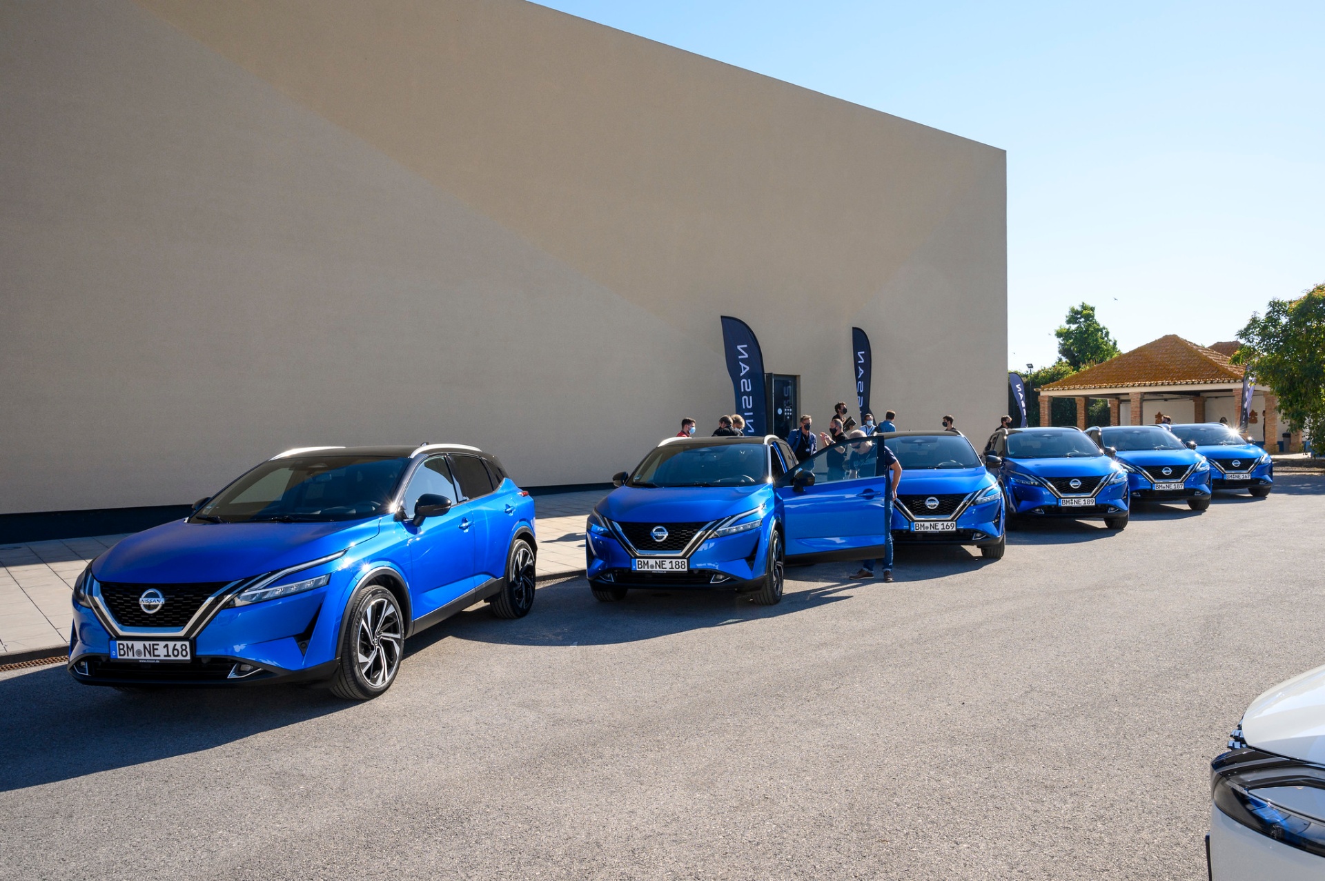 Frota de Nissan Qashqai azuis alinhada com bandeiras Nissan
