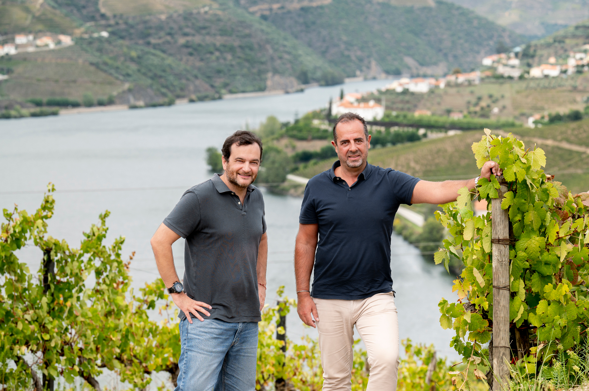Dois produtores nas vinhas com o rio Douro em fundo