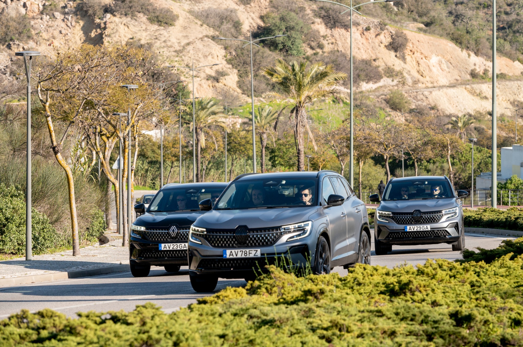 Três Renault Austral em circulação em estrada algarvia com palmeiras