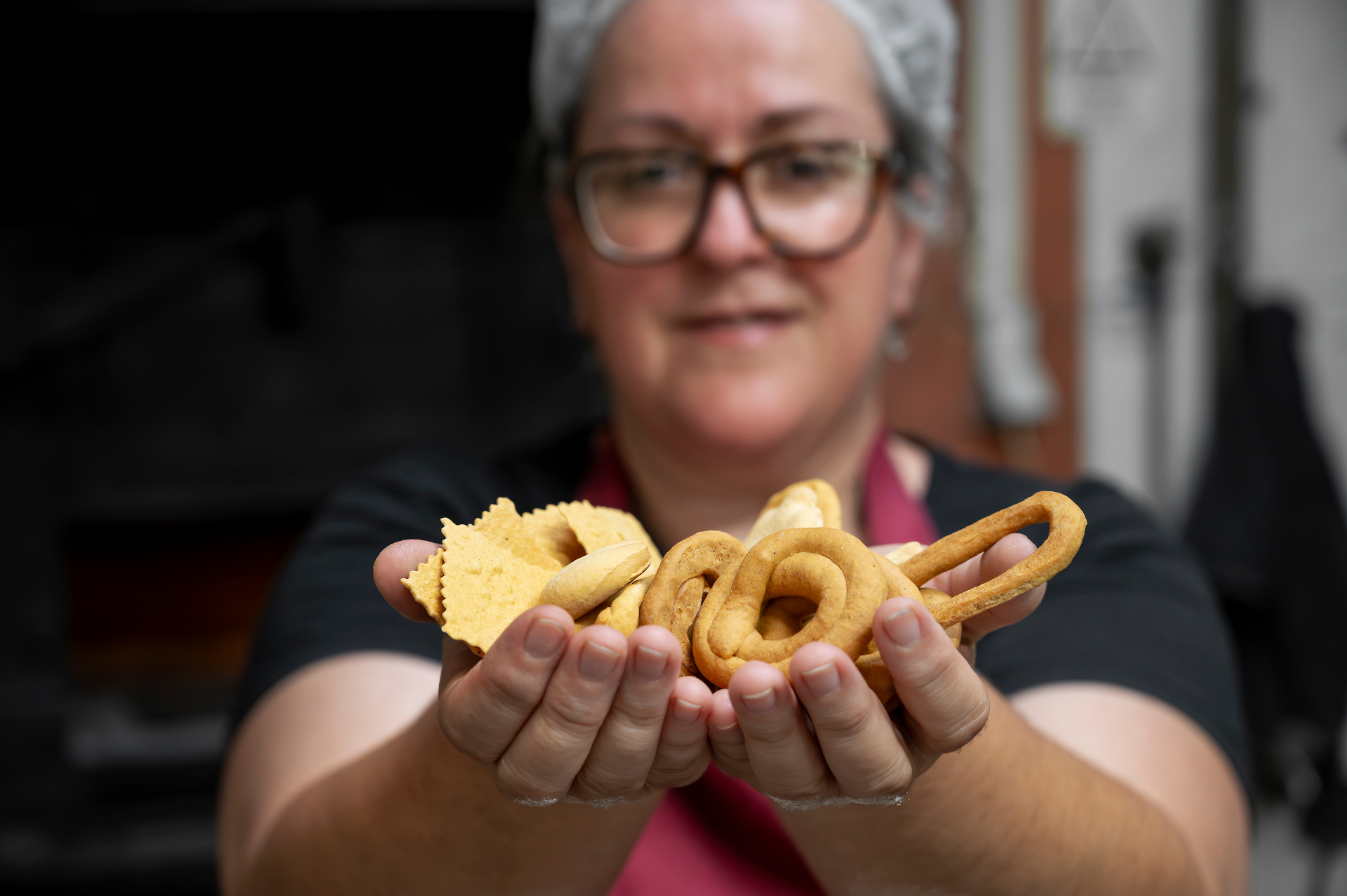 Mãos a apresentar biscoitos tradicionais de Valongo, incluindo regueifa e biscoitos de azeite