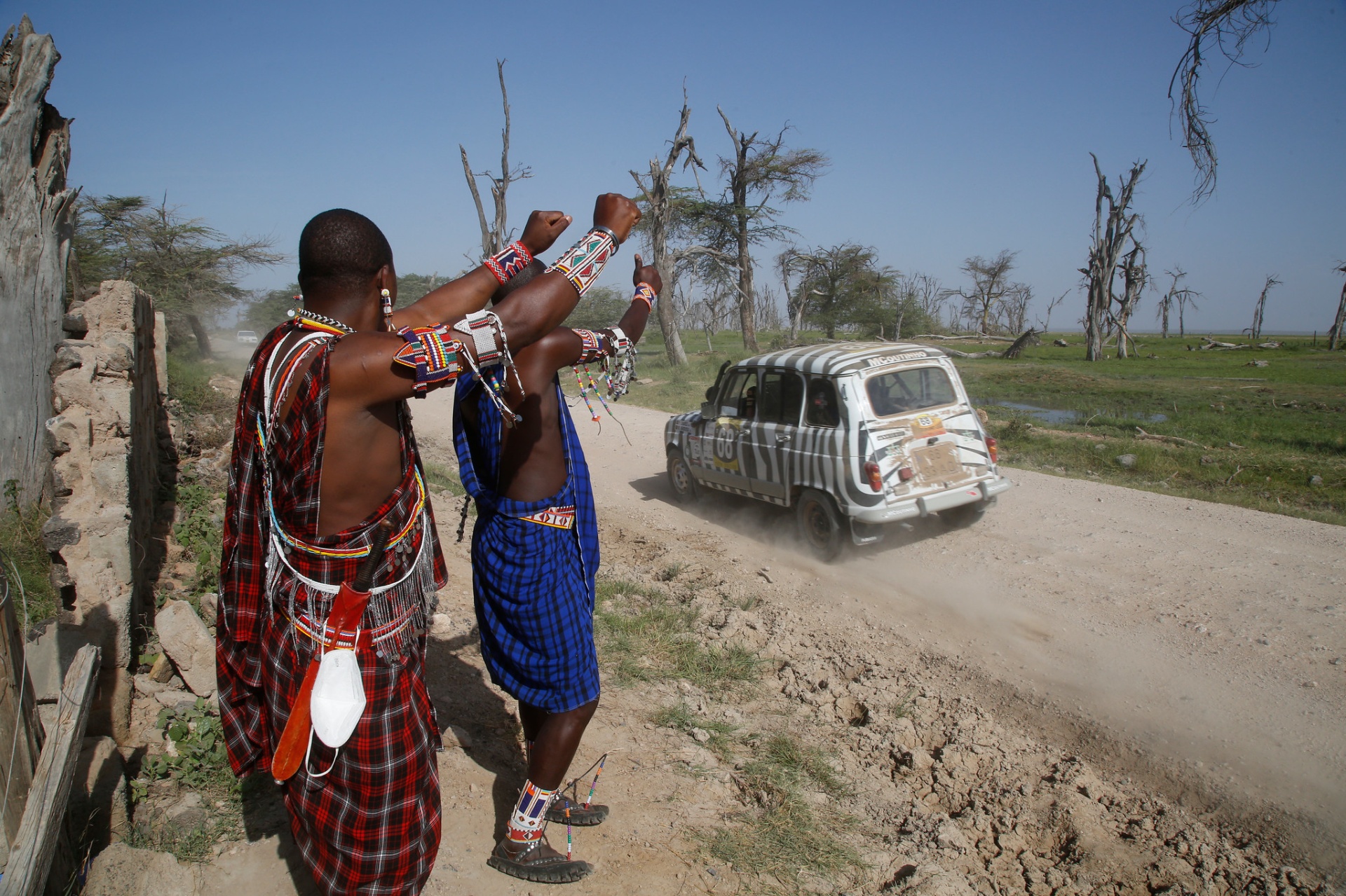 Guerreiros Maasai saúdam a passagem da Renault 4L numa pista de terra