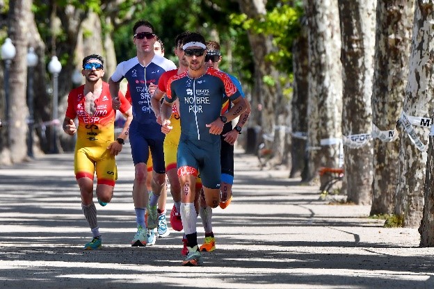 Pelotão de corredores liderado pelo atleta português Nobre num troço urbano arborizado
