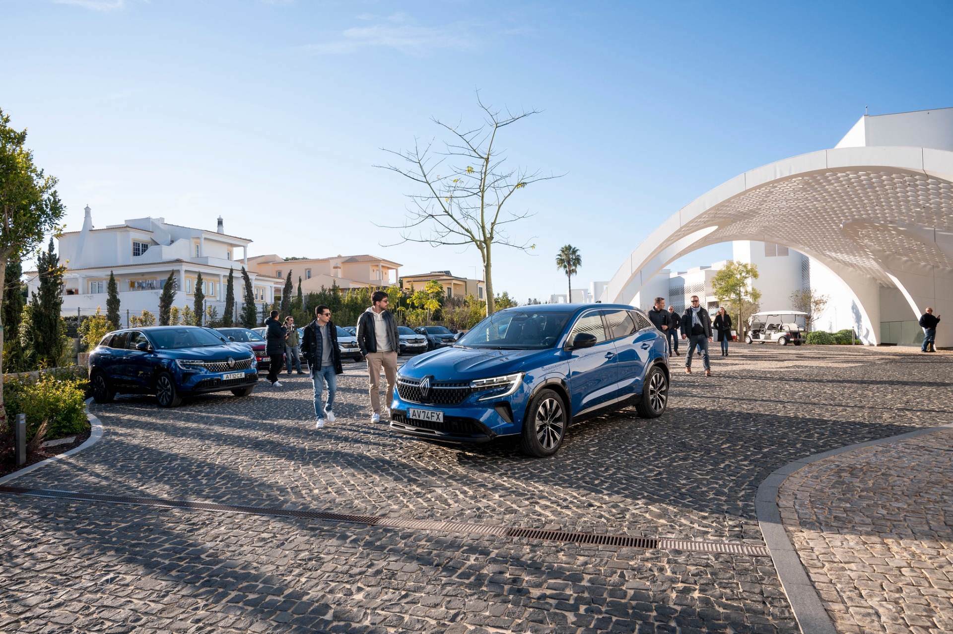 Renault Austral azul em pátio de resort com arquitetura branca