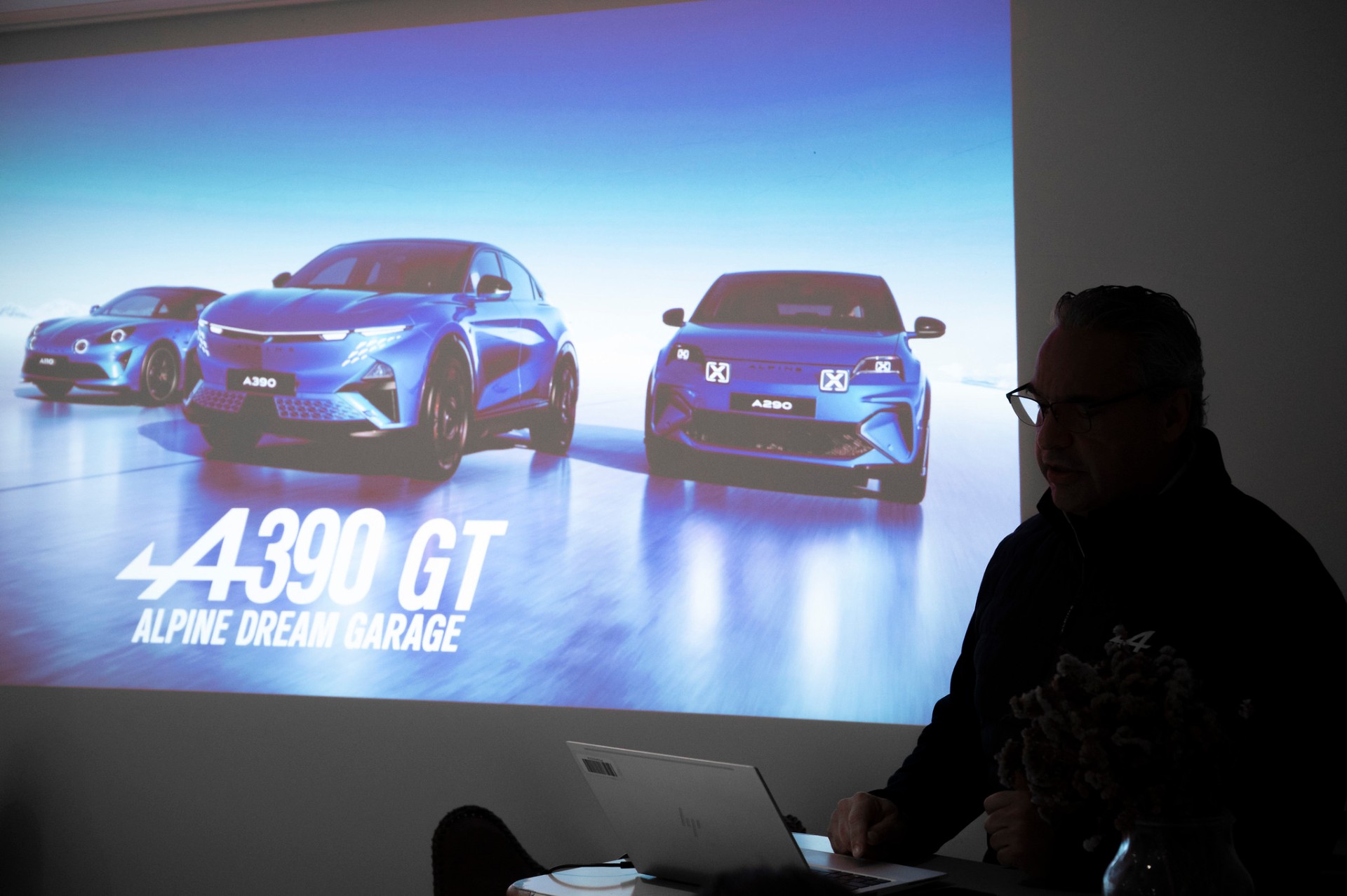 Apresentação Alpine Dream Garage com projeção do A390 GT, A390 e A290 ao lado de orador