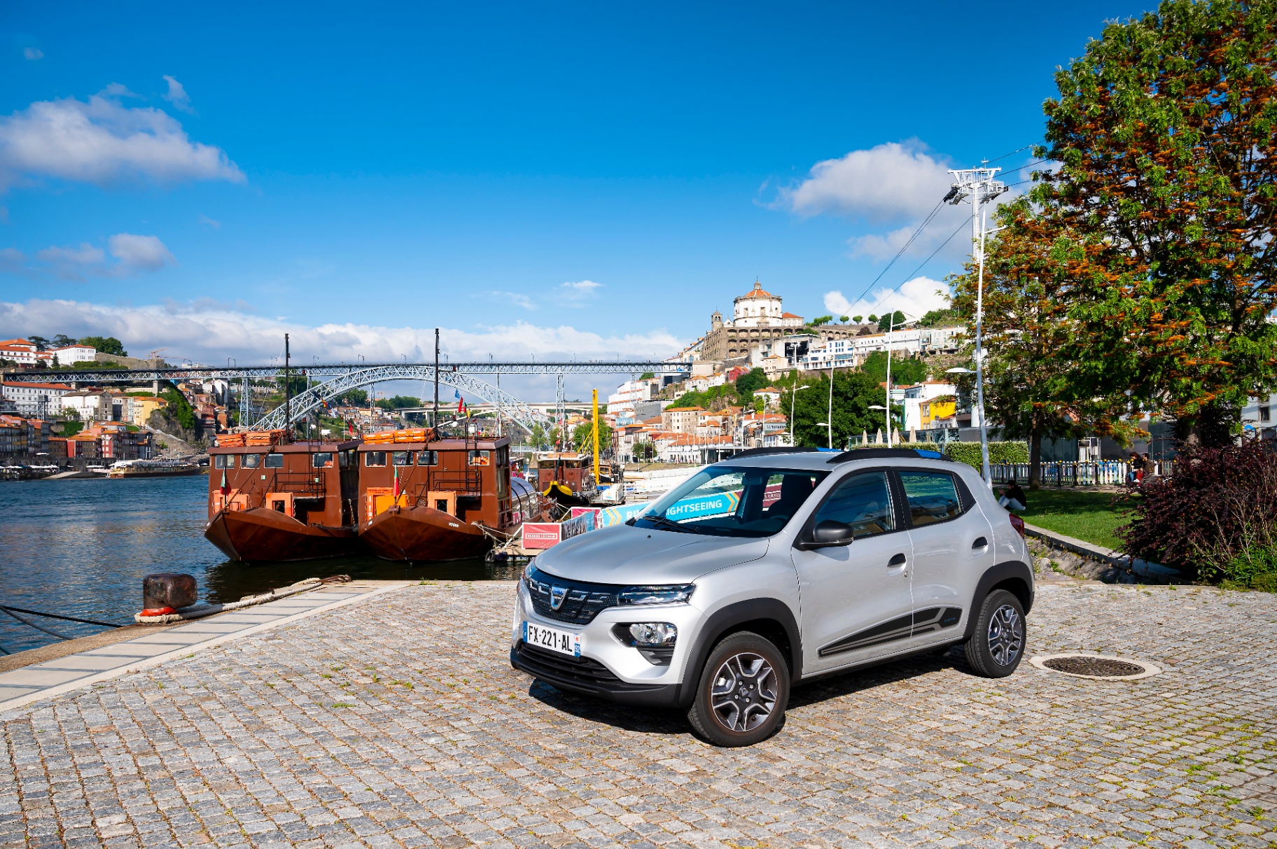 Dacia Spring junto ao rio Douro com a Ponte D. Luís ao fundo
