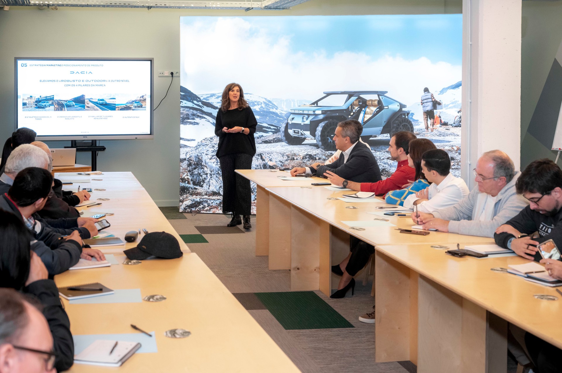 Sessão de trabalho da equipa Dacia em formato workshop com mesa corrida e ecrã de apresentação