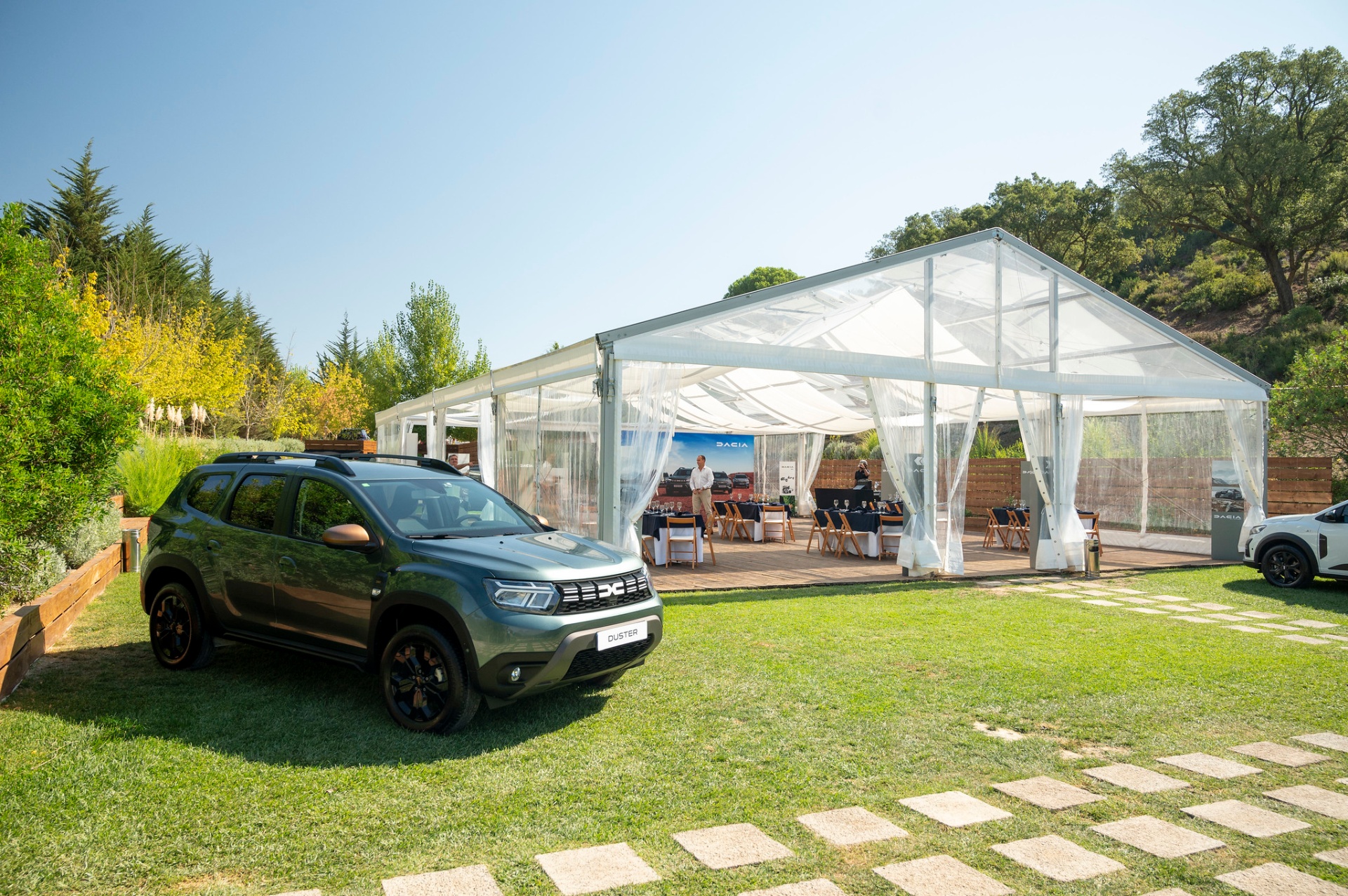 Dacia Duster verde estacionado junto à tenda principal do evento na Serra da Arrábida