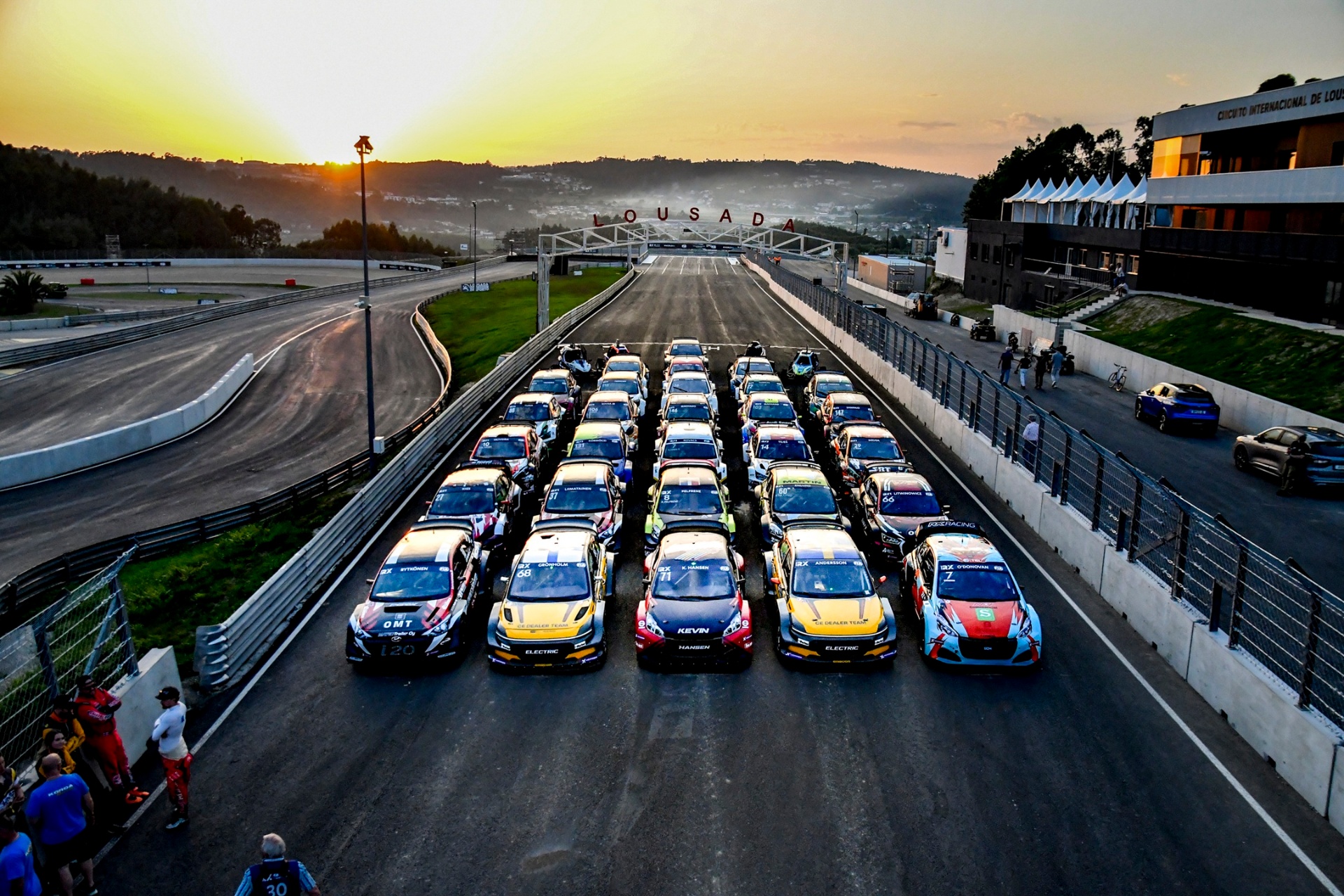 Grelha de partida do WRX no Eurocircuito de Lousada ao amanhecer, com dezenas de carros alinhados sob o arco LOUSADA