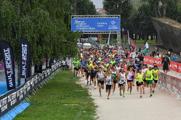 Largada da prova de corrida do Europeu de Triatlo Multisport sob o arco Coimbra 2024 no Parque Verde do Mondego
