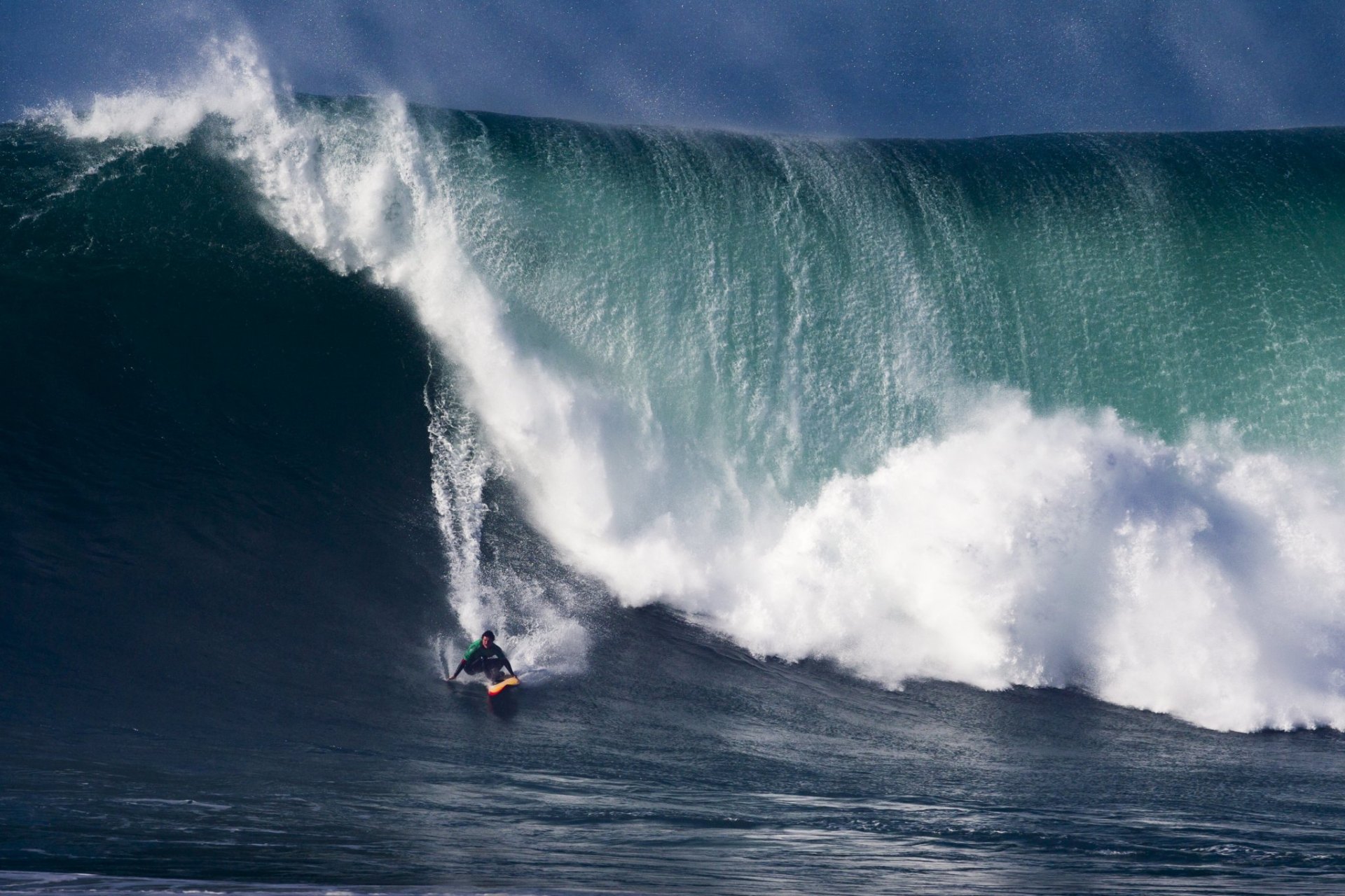 Surfista a descer uma onda gigante na Nazaré