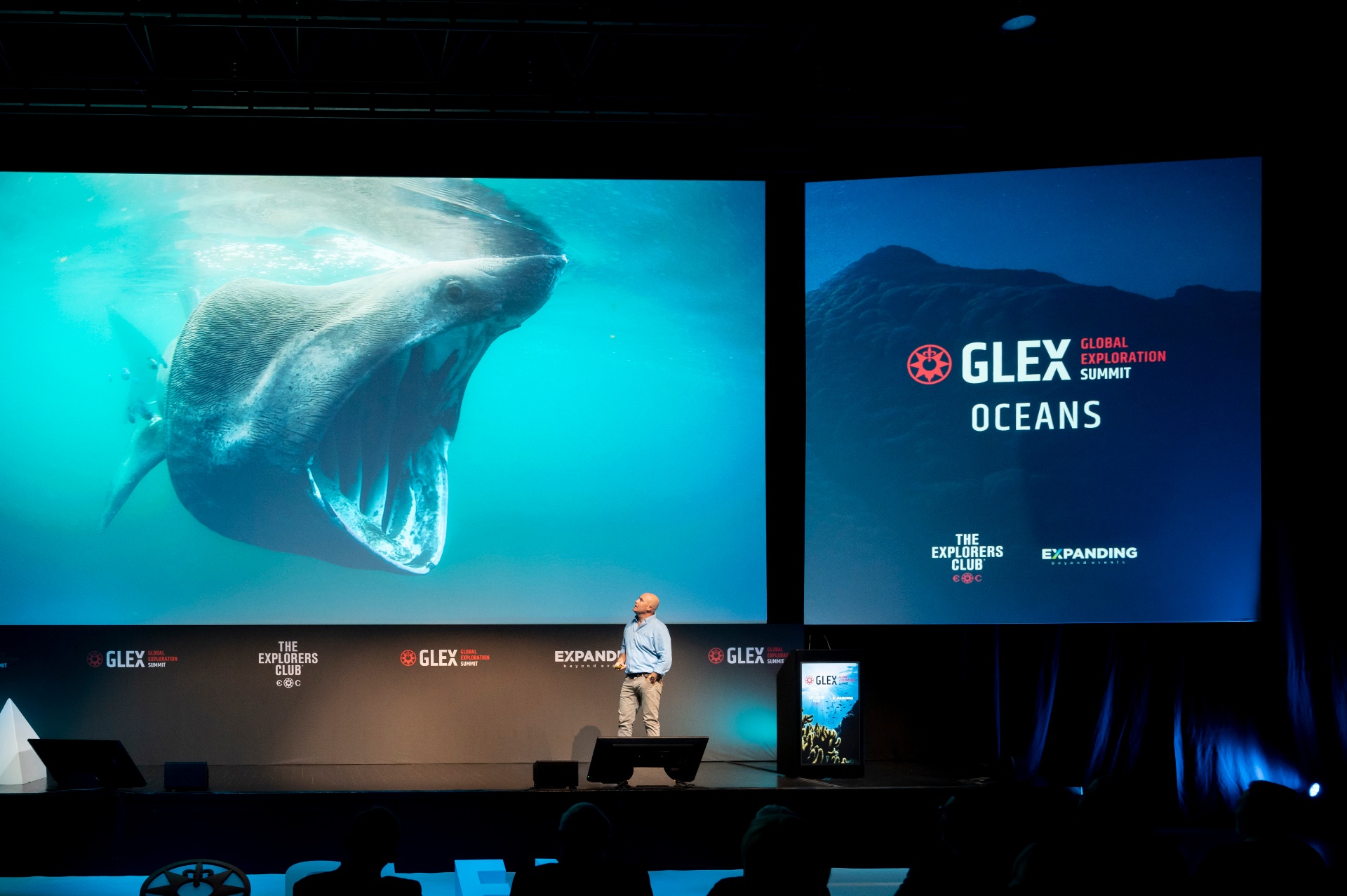 Orador em palco da GLEX Oceans com imagem de tubarão-frade projectada em ecrã gigante