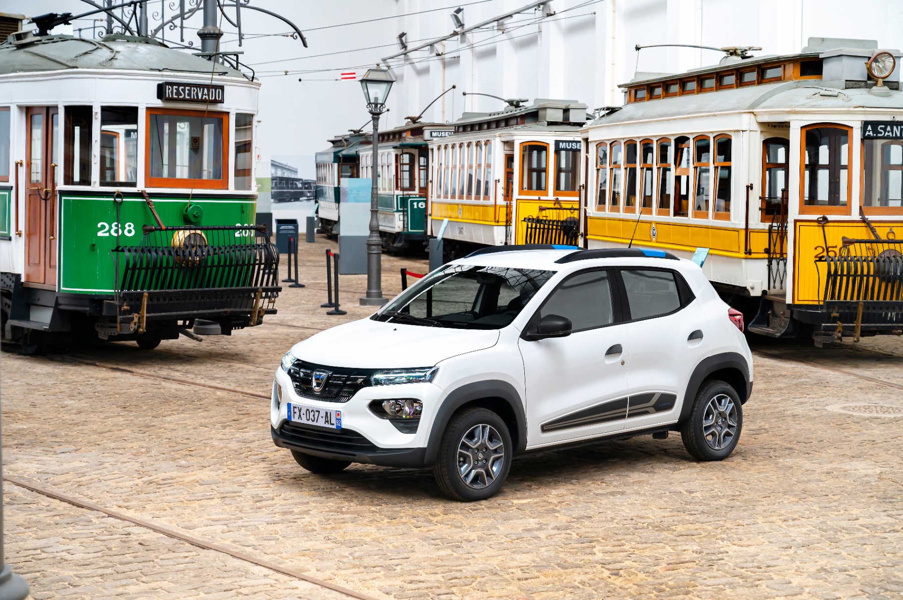 Dacia Spring branco entre elétricos históricos no Museu do Carro Eléctrico do Porto