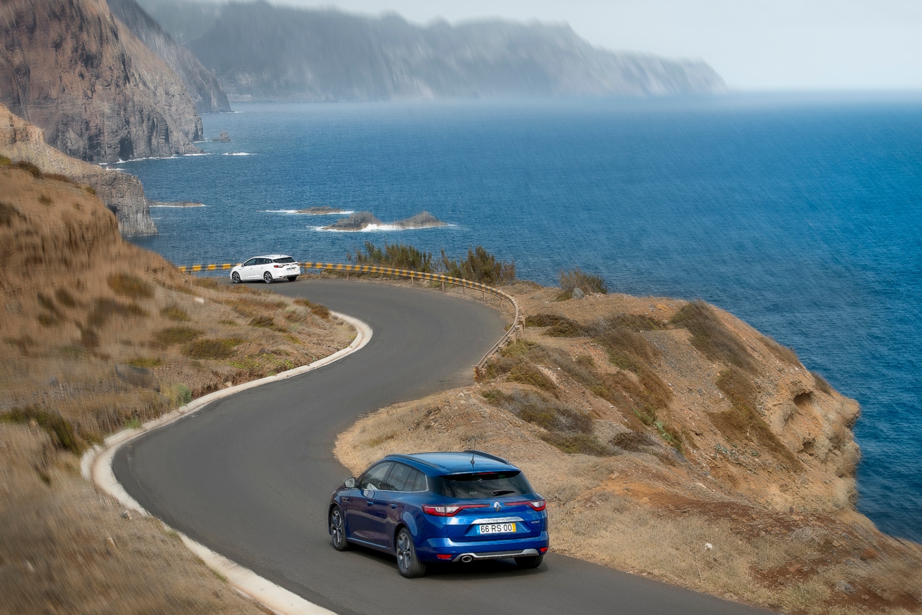Duas Mégane Sport Tourer em estrada de falésia sobre o mar
