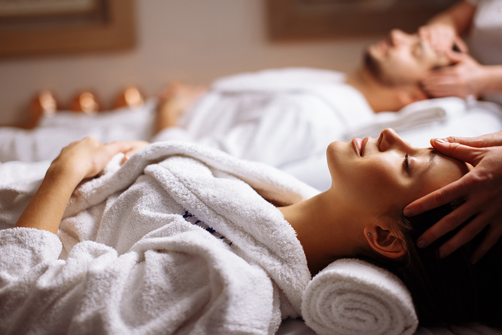 Casal a receber massagem terapêutica em ambiente de spa