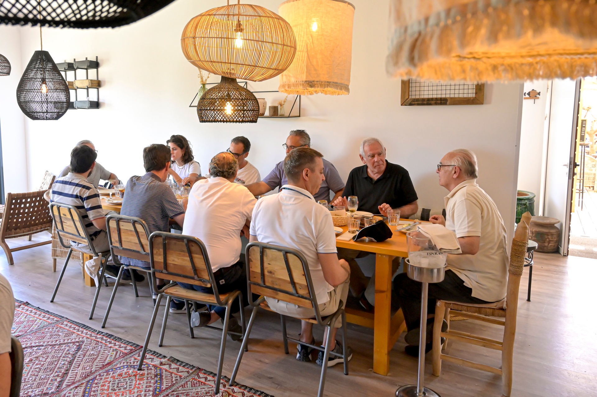 Jornalistas à mesa em almoço regional, em sala com candeeiros de fibra natural