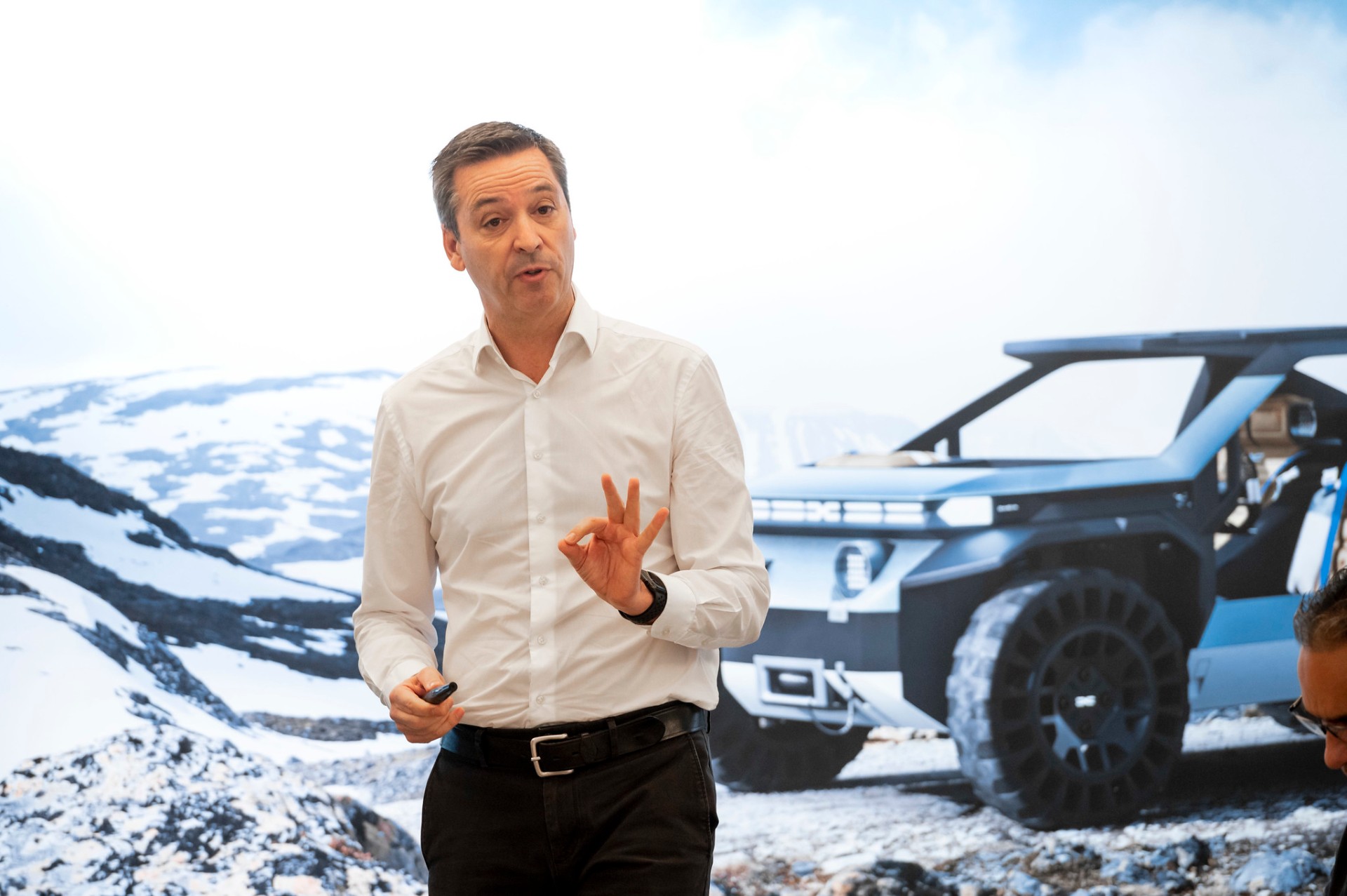 Orador apresenta resultados comerciais Dacia diante de ecrã com concept car ao fundo