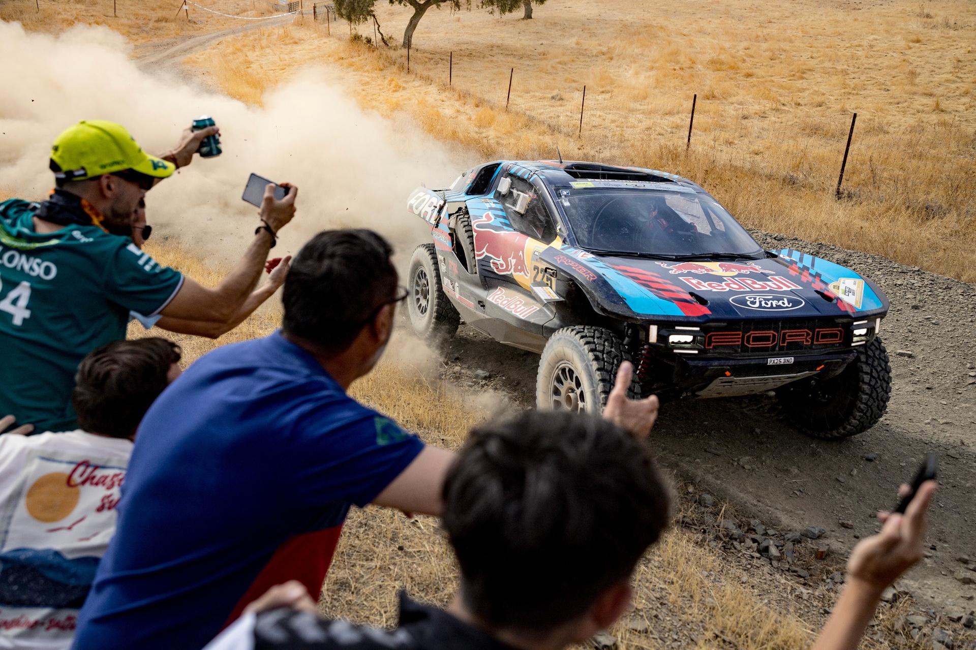 Ford Raptor da Red Bull em prova levantando poeira perante adeptos a fotografar