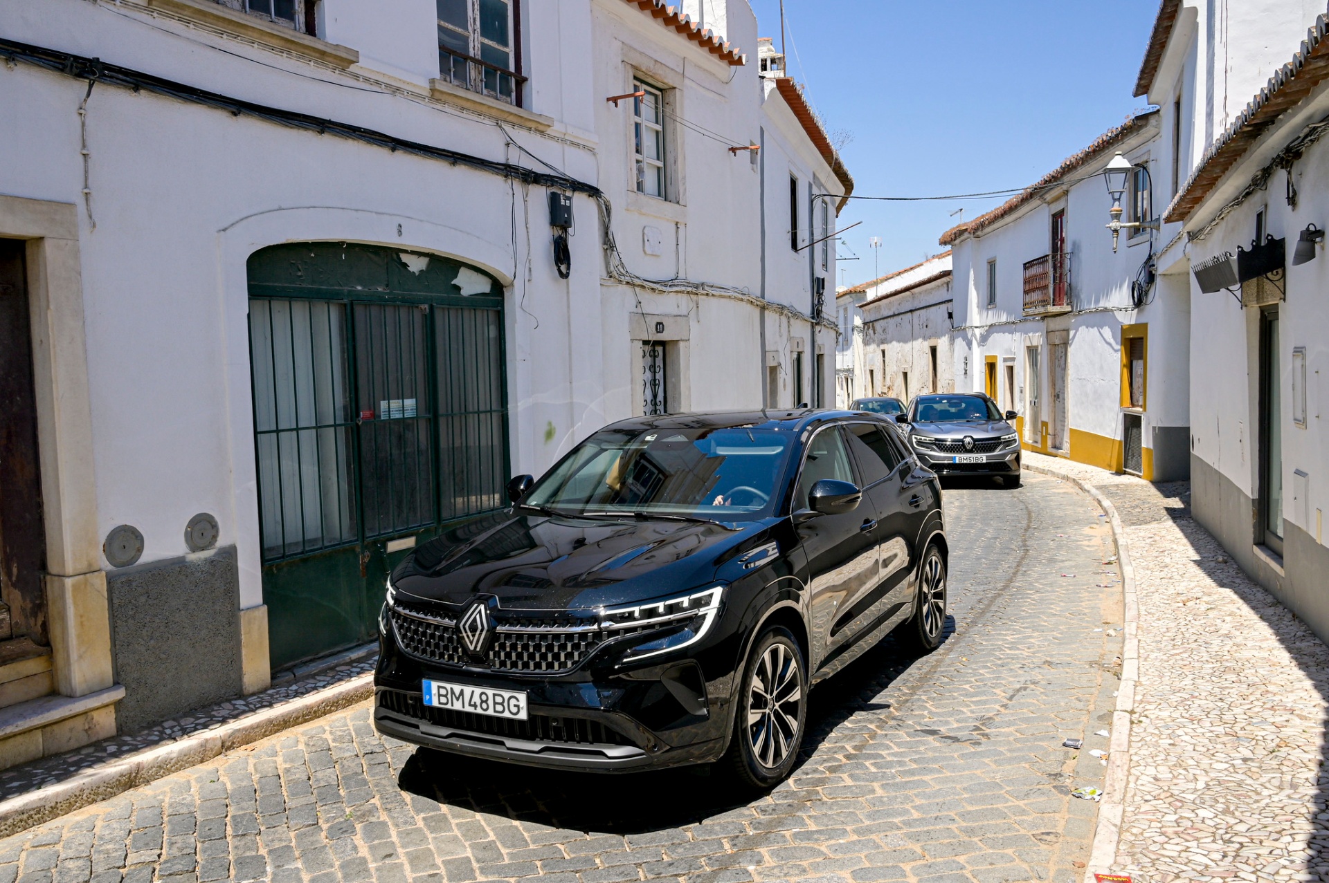 Renault Austral preto e cinzento em rua estreita de aldeia alentejana com casas caiadas